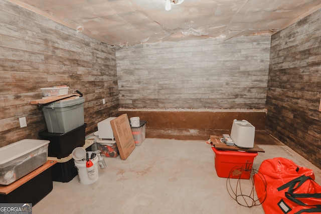 interior space with concrete floors and wooden walls