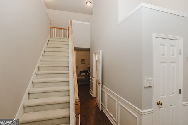 stairs featuring a high ceiling and hardwood / wood-style floors