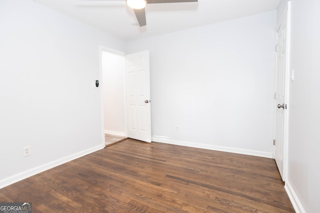 empty room with ceiling fan and dark hardwood / wood-style flooring