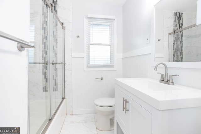 full bathroom with combined bath / shower with glass door, vanity, and toilet