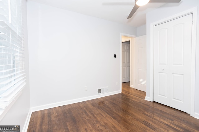 unfurnished bedroom featuring a closet, ceiling fan, and dark wood-type flooring