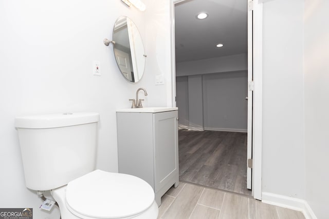 bathroom with vanity, toilet, and hardwood / wood-style flooring