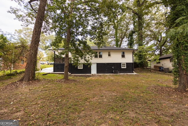 rear view of property with a patio and a lawn