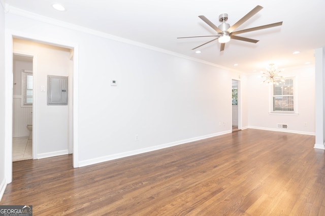 unfurnished room featuring crown molding, dark hardwood / wood-style flooring, ceiling fan, and electric panel