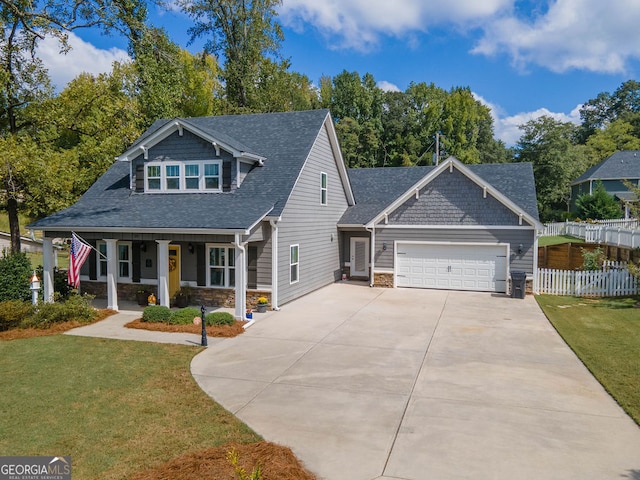 view of front of house featuring a garage, a front yard, and a porch