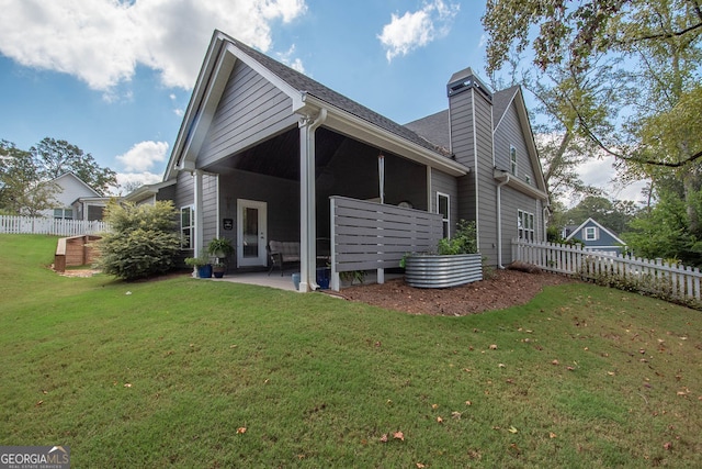 rear view of house with a patio area and a yard