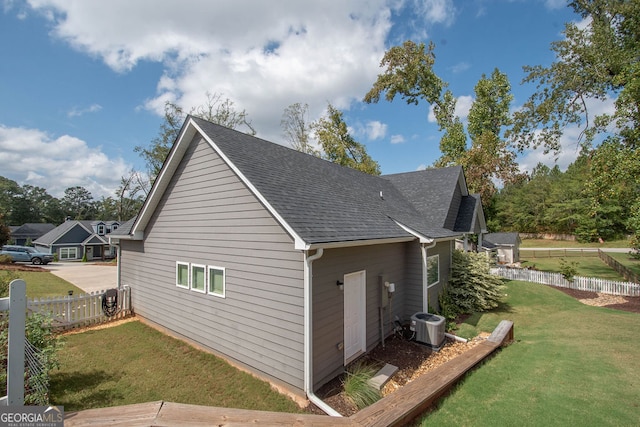 view of property exterior featuring a lawn and central air condition unit