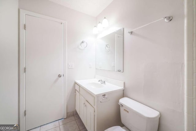 bathroom with toilet, vanity, and tile patterned flooring