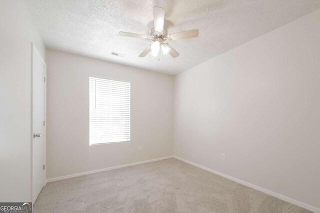 unfurnished room with visible vents, baseboards, carpet floors, a textured ceiling, and a ceiling fan