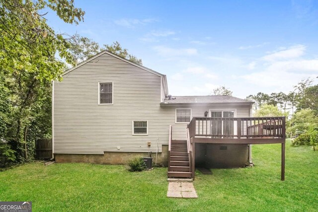 rear view of house with a wooden deck, a lawn, a shingled roof, and stairway