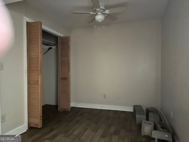 unfurnished bedroom featuring ceiling fan, dark wood-type flooring, and a closet