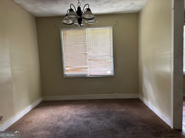 unfurnished dining area featuring carpet, a chandelier, and a textured ceiling