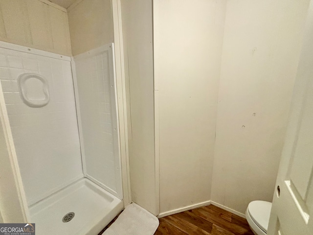 bathroom featuring a shower, toilet, and hardwood / wood-style flooring