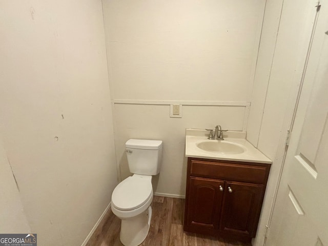 bathroom featuring toilet, hardwood / wood-style flooring, and vanity