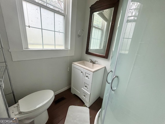 bathroom featuring vanity, toilet, wood-type flooring, and a shower