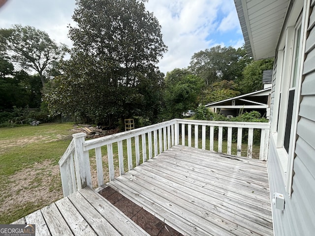 wooden terrace featuring a lawn