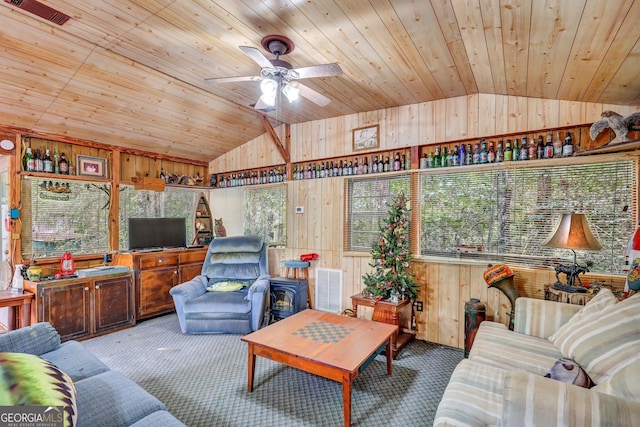 carpeted living room featuring wood ceiling, lofted ceiling, ceiling fan, and wooden walls