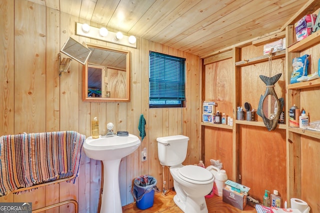 bathroom with toilet, wood walls, and wooden ceiling