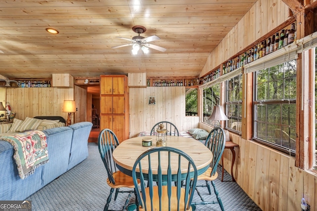 dining area featuring wooden ceiling, vaulted ceiling, wood walls, and ceiling fan