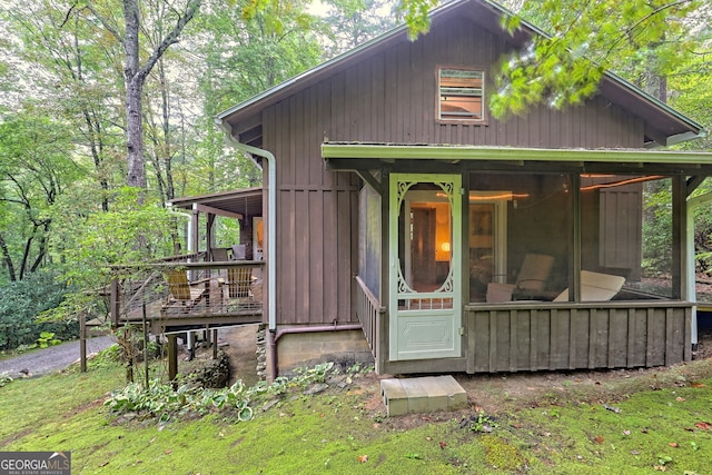 back of house featuring a yard and a sunroom