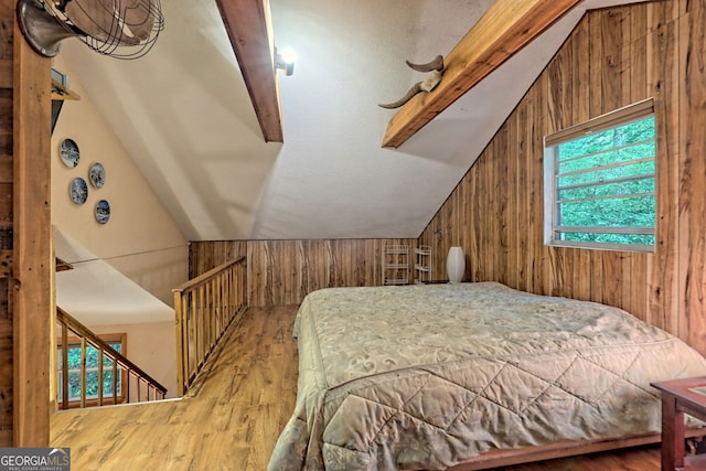 bedroom featuring vaulted ceiling, hardwood / wood-style flooring, and wooden walls