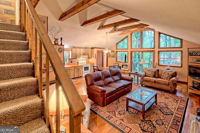 living room with high vaulted ceiling, an inviting chandelier, beam ceiling, and hardwood / wood-style flooring