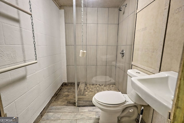 bathroom featuring tiled shower and toilet