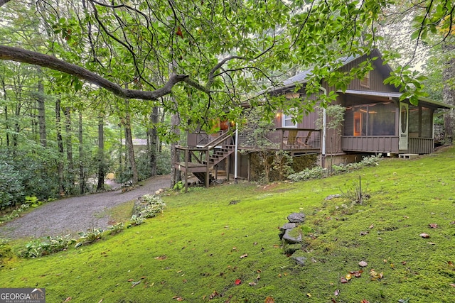 view of yard with a wooden deck and a sunroom