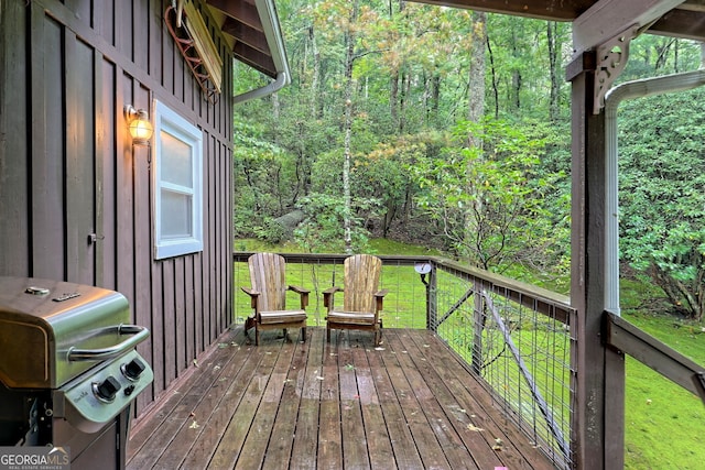 wooden deck with a yard and area for grilling