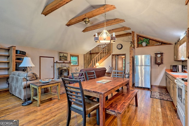 dining room featuring lofted ceiling with beams and wood-type flooring