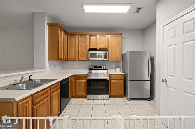 kitchen with light tile patterned floors, stainless steel appliances, and sink