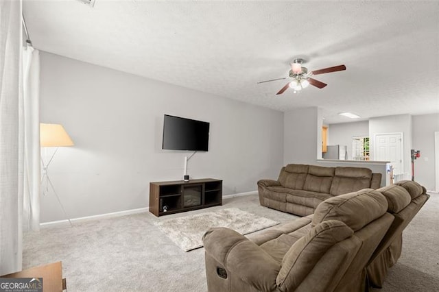 living room with ceiling fan, light colored carpet, and a textured ceiling