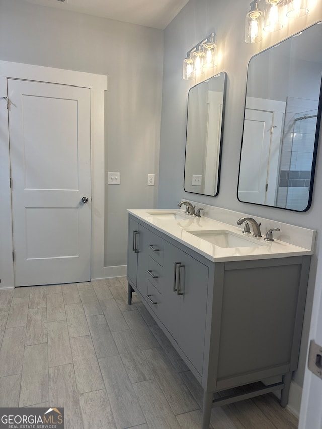 bathroom featuring a shower with shower door, hardwood / wood-style flooring, and vanity