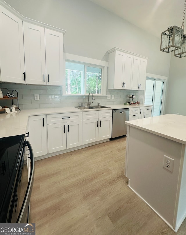 kitchen featuring dishwasher, light hardwood / wood-style floors, sink, white cabinetry, and black stove