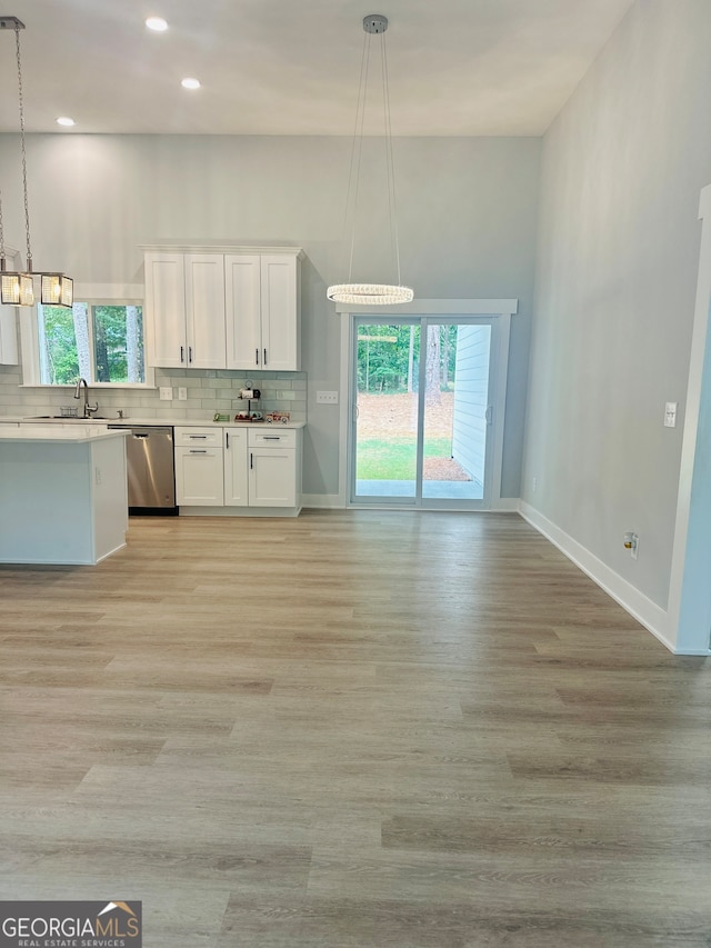 kitchen featuring white cabinets, plenty of natural light, pendant lighting, and stainless steel dishwasher