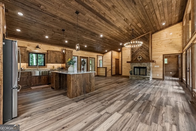 bar featuring stainless steel fridge, hanging light fixtures, dark wood-type flooring, and wood ceiling