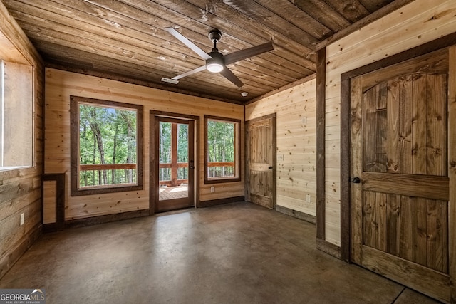 interior space with wooden ceiling, ceiling fan, and wooden walls