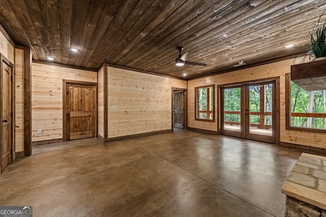 unfurnished room featuring wooden ceiling, ceiling fan, and wooden walls