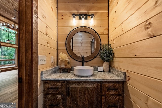 bathroom featuring vanity and wood walls