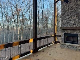 wooden deck with an outdoor stone fireplace