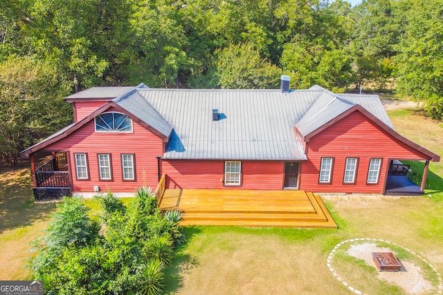 view of front of property featuring a wooden deck, a front yard, and a patio area