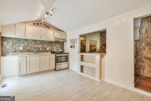 kitchen with vaulted ceiling, stainless steel electric stove, light hardwood / wood-style flooring, decorative backsplash, and rail lighting