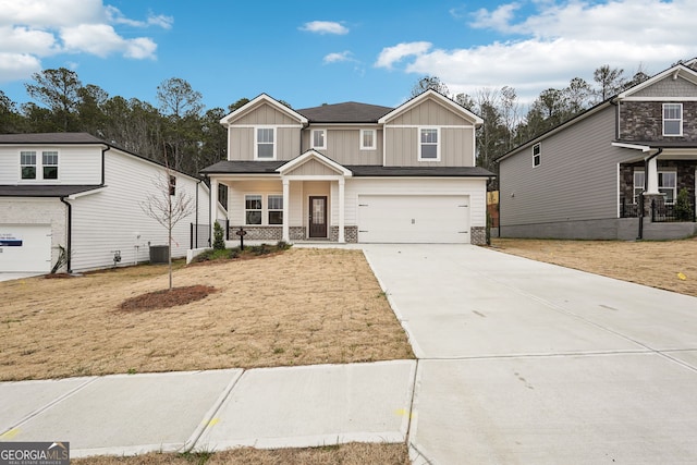 view of front of home with a porch, a garage, central air condition unit, and a front lawn