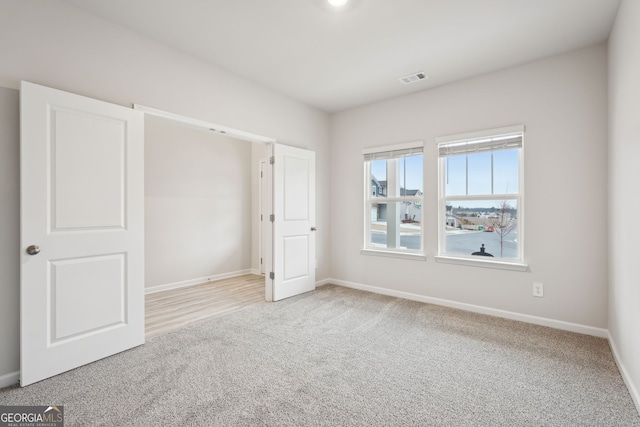 unfurnished bedroom featuring light carpet