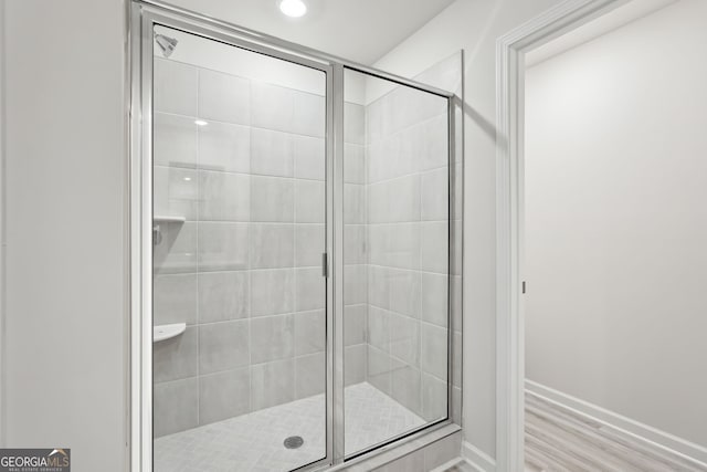 bathroom with hardwood / wood-style floors and walk in shower