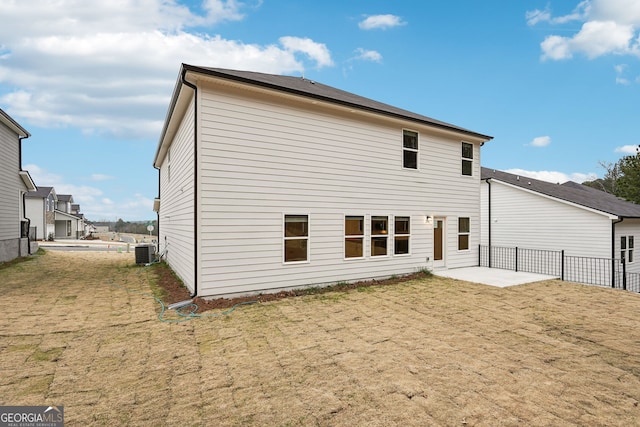 rear view of house featuring central AC unit, a patio, and a lawn