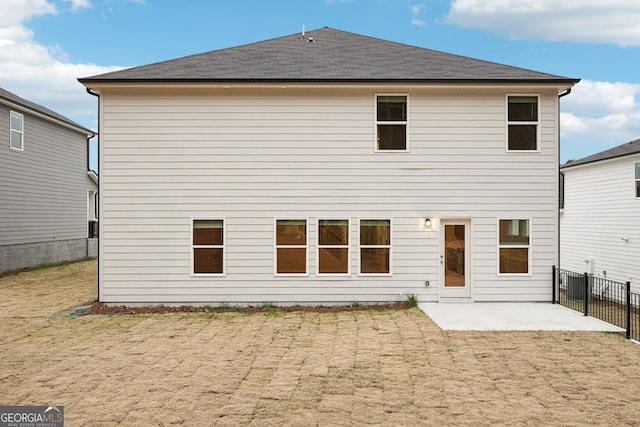 back of property with a lawn and a patio