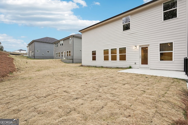 back of property with a yard and a patio