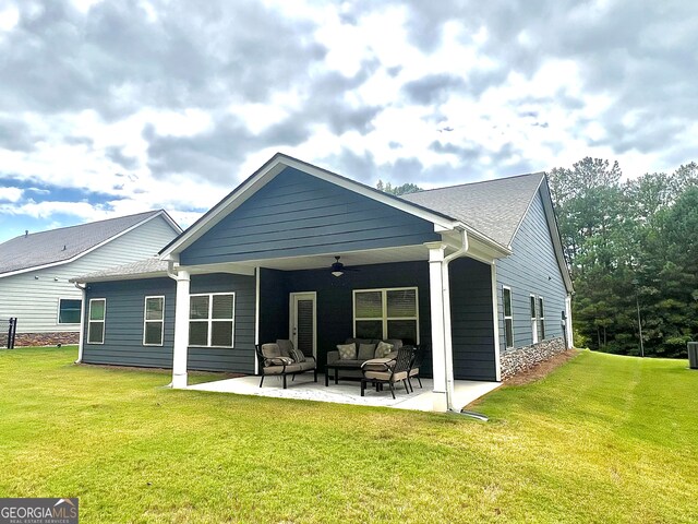 rear view of property with a yard, ceiling fan, a patio, and an outdoor hangout area