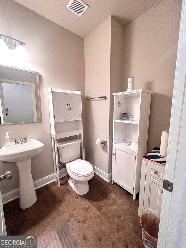 bathroom with toilet and hardwood / wood-style flooring